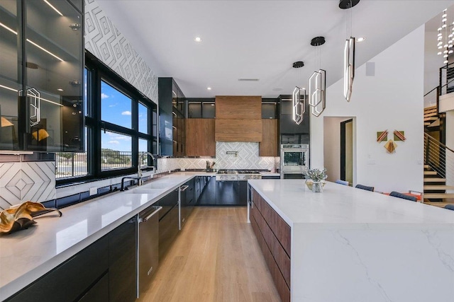 1806 Lauren Dr, Spicewood, TX 78669 - kitchen featuring modern cabinets, backsplash, light wood finished floors, appliances with stainless steel finishes, and glass insert cabinets