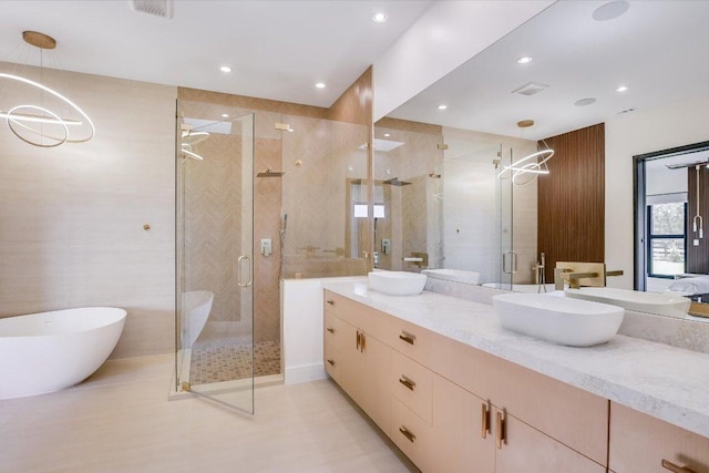1806 Lauren Dr, Spicewood, TX 78669 - full bathroom featuring vanity, a stall shower, a soaking tub, recessed lighting, and a chandelier