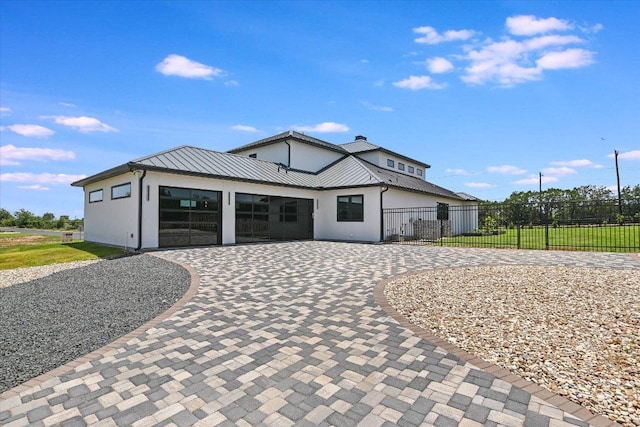 1806 Lauren Dr, Spicewood, TX 78669 - modern farmhouse style home with curved driveway, a standing seam roof, a metal roof, and a garage