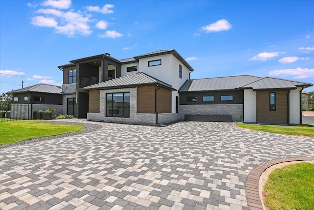 1806 Lauren Dr, Spicewood, TX 78669 - contemporary house with a standing seam roof, stone siding, a metal roof, and decorative driveway