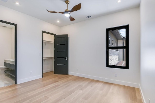 1806 Lauren Dr, Spicewood, TX 78669 - unfurnished bedroom with light wood-style flooring, a spacious closet, connected bathroom, recessed lighting, and a closet