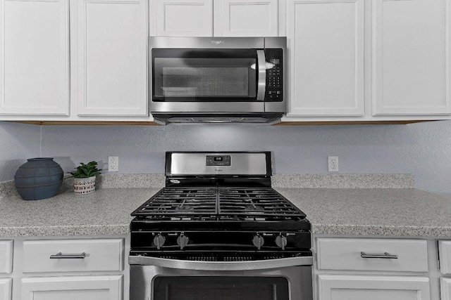906 Pecos Cv, Leander, TX 78641 - kitchen with appliances with stainless steel finishes, light countertops, and white cabinets
