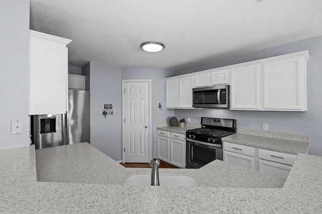 906 Pecos Cv, Leander, TX 78641 - kitchen featuring appliances with stainless steel finishes, white cabinetry, and light countertops