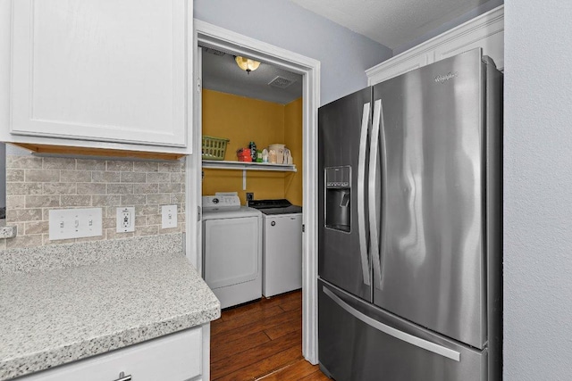 906 Pecos Cv, Leander, TX 78641 - kitchen featuring stainless steel fridge, independent washer and dryer, white cabinetry, dark wood-style floors, and tasteful backsplash