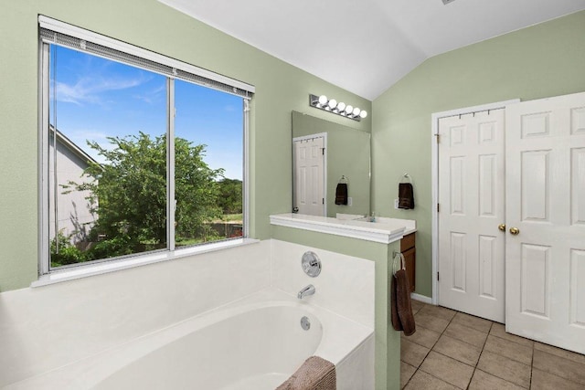 906 Pecos Cv, Leander, TX 78641 - bathroom with vaulted ceiling, a bath, tile patterned flooring, and vanity