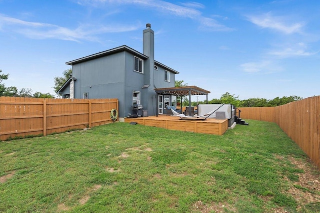 906 Pecos Cv, Leander, TX 78641 - rear view of house with a fenced backyard, a wooden deck, a chimney, and a jacuzzi