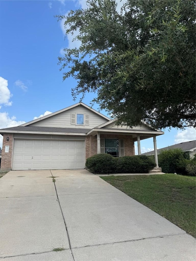 209 Lake Washington Dr, Kyle, TX 78640 - single story home featuring concrete driveway, brick siding, an attached garage, a front yard, and a porch