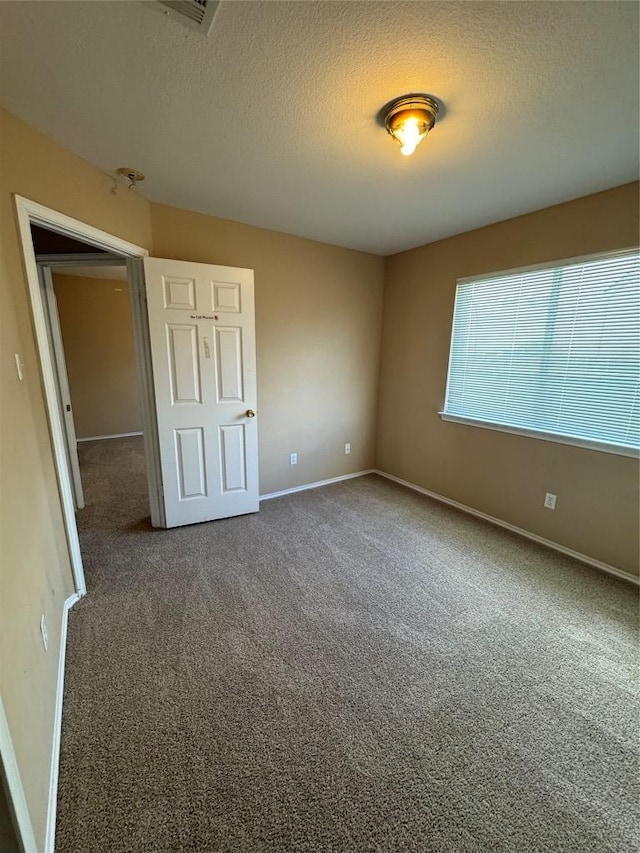 209 Lake Washington Dr, Kyle, TX 78640 - carpeted empty room with baseboards and a textured ceiling
