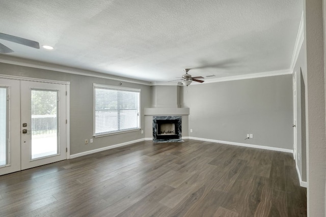 2801 Adelen Ln, Round Rock, TX 78664 - unfurnished living room featuring a ceiling fan, crown molding, a textured ceiling, a premium fireplace, and dark wood finished floors