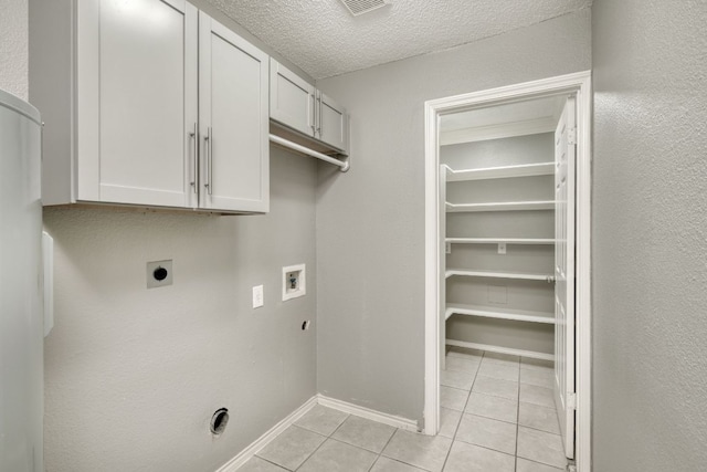 2801 Adelen Ln, Round Rock, TX 78664 - washroom with hookup for an electric dryer, cabinet space, hookup for a washing machine, light tile patterned floors, and a textured ceiling