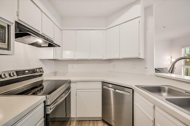 6000 Shepherd Mountain Cv Unit 1805, Austin, TX 78730 - kitchen with stainless steel appliances, under cabinet range hood, white cabinetry, light countertops, and light wood-style flooring