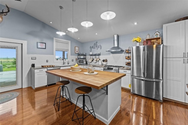 1200 County Road 149, Georgetown, TX 78626 - kitchen with stainless steel appliances, wall chimney exhaust hood, wood counters, vaulted ceiling, and dark wood-style floors