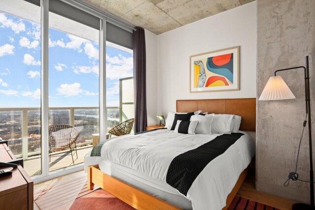 48 E Ave Unit 2707, Austin, TX 78701 - bedroom featuring multiple windows, access to outside, and wood finished floors