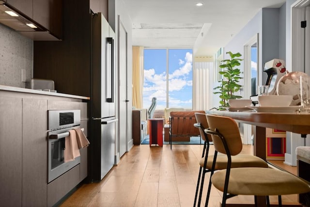 48 E Ave Unit 2707, Austin, TX 78701 - kitchen featuring appliances with stainless steel finishes, light wood-style flooring, modern cabinets, ventilation hood, and recessed lighting