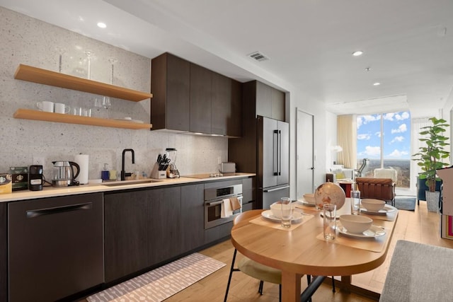 48 E Ave Unit 2707, Austin, TX 78701 - kitchen featuring appliances with stainless steel finishes, dark brown cabinetry, light wood-type flooring, light countertops, and modern cabinets