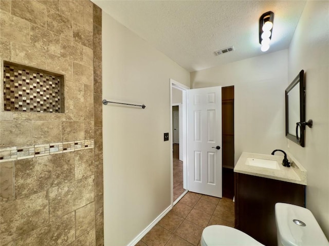 6400 Jennings Dr, Austin, TX 78727 - bathroom with vanity, tile patterned floors, a textured ceiling, and a tile shower