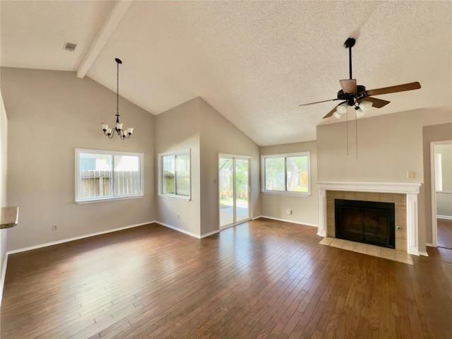 6400 Jennings Dr, Austin, TX 78727 - unfurnished living room featuring dark wood-type flooring, a ceiling fan, a tile fireplace, a chandelier, and a textured ceiling