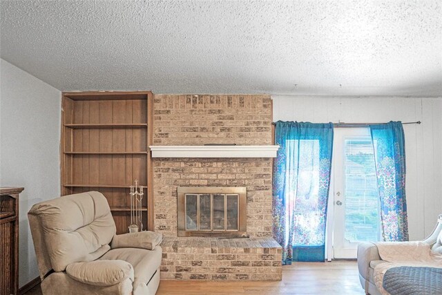 906 Lynn Ln, Copperas Cove, TX 76522 - living area featuring a textured ceiling, a fireplace, and wood finished floors