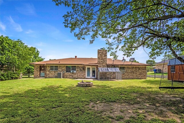 906 Lynn Ln, Copperas Cove, TX 76522 - rear view of house with a fire pit, a chimney, brick siding, and a storage unit