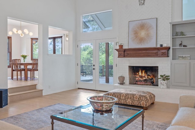 6302 Gato Path, Austin, TX 78731 - living area featuring wood finished floors, a brick fireplace, a towering ceiling, french doors, and a chandelier