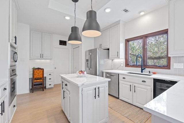 6302 Gato Path, Austin, TX 78731 - kitchen featuring appliances with stainless steel finishes, tasteful backsplash, white cabinets, a kitchen island, and hanging light fixtures