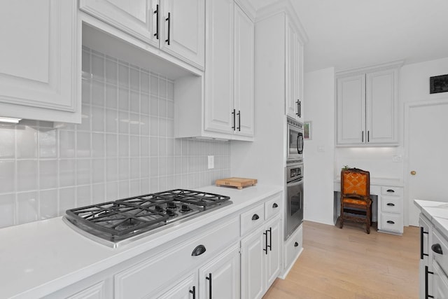 6302 Gato Path, Austin, TX 78731 - kitchen with stainless steel appliances, tasteful backsplash, light countertops, and white cabinets