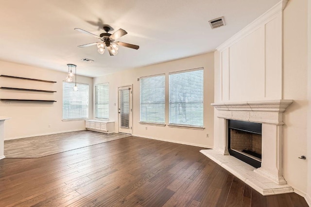 65 White Magnolia Cir, Lakeway, TX 78734 - unfurnished living room featuring ceiling fan, a fireplace with raised hearth, and dark wood-style floors