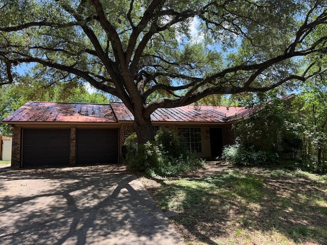 9705 Marlborough Dr, Austin, TX 78753 - ranch-style house featuring an attached garage, brick siding, driveway, and a metal roof