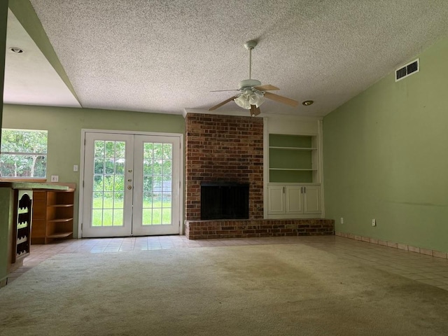 9705 Marlborough Dr, Austin, TX 78753 - unfurnished living room featuring a ceiling fan, a textured ceiling, carpet flooring, a fireplace, and built in shelves