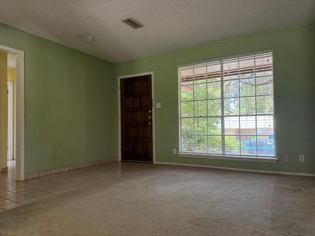 9705 Marlborough Dr, Austin, TX 78753 - carpeted empty room featuring a textured ceiling and tile patterned flooring