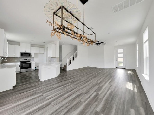 12416 Anthology St, Manor, TX 78653 - unfurnished living room featuring stairs and wood finished floors