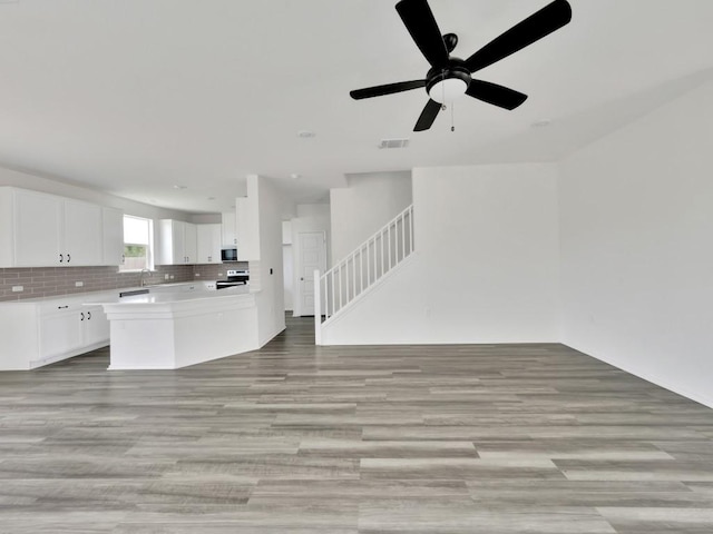 12416 Anthology St, Manor, TX 78653 - kitchen with open floor plan, stainless steel appliances, light wood-style floors, light countertops, and white cabinets