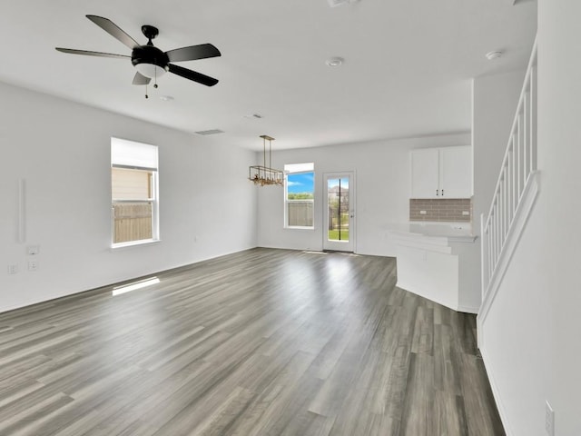 12416 Anthology St, Manor, TX 78653 - unfurnished living room featuring wood finished floors, a ceiling fan, and a chandelier