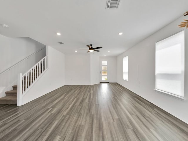 12416 Anthology St, Manor, TX 78653 - unfurnished living room with wood finished floors, ceiling fan, stairs, and recessed lighting