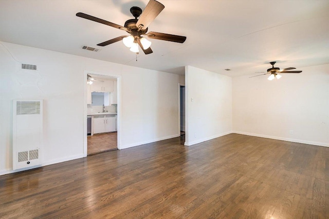 212 W 55th St, Austin, TX 78751 - empty room featuring a heating unit, a ceiling fan, and dark wood-style flooring