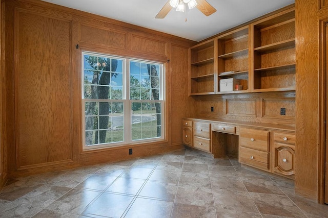 208 Norwood Cv, Georgetown, TX 78628 - unfurnished office featuring built in desk, ceiling fan, healthy amount of natural light, and wood walls