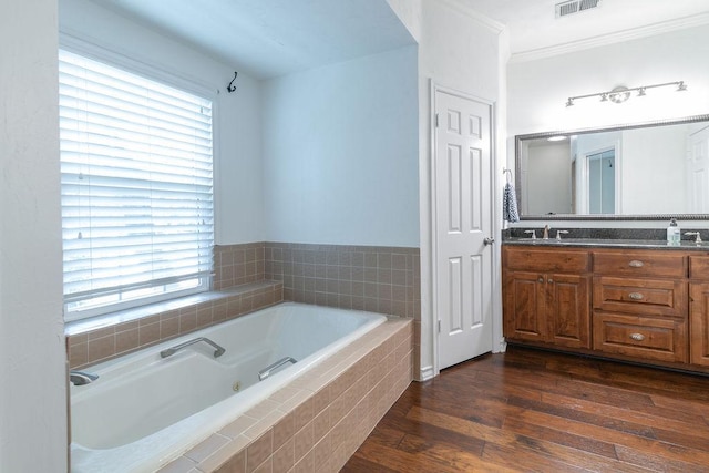 208 Norwood Cv, Georgetown, TX 78628 - bathroom with a tub with jets, double vanity, plenty of natural light, crown molding, and wood finished floors