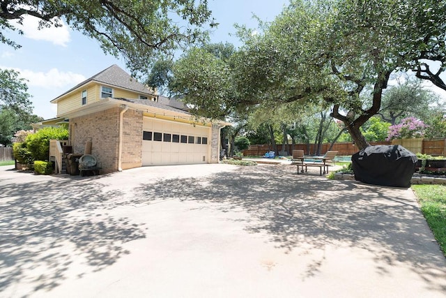 208 Norwood Cv, Georgetown, TX 78628 - view of side of home with brick siding, a garage, a swimming pool, and driveway