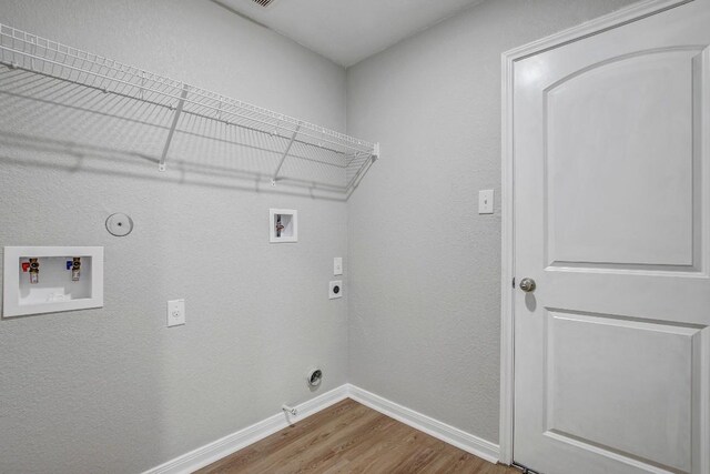 1326 Amy Dr, Kyle, TX 78640 - laundry room with gas dryer hookup, wood finished floors, washer hookup, hookup for an electric dryer, and a textured wall