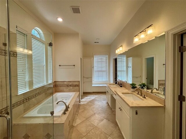 1733 Canonero Dr, Austin, TX 78746 - full bathroom with double vanity, a garden tub, a shower stall, and tile patterned flooring