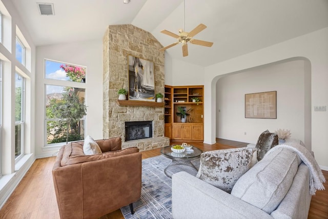 100 Broad Vista Ct, Georgetown, TX 78628 - living area with a fireplace, wood finished floors, high vaulted ceiling, ceiling fan, and arched walkways