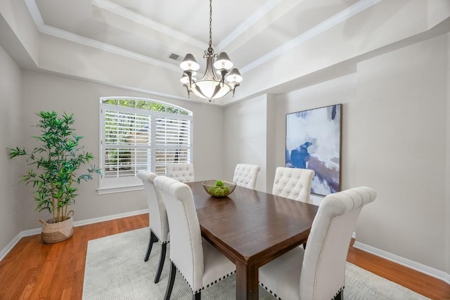 100 Broad Vista Ct, Georgetown, TX 78628 - dining space with a raised ceiling, a chandelier, light wood-style floors, and ornamental molding