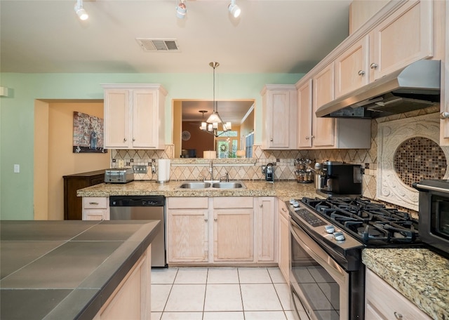 5102 Coppermead Ln, Austin, TX 78754 - kitchen with stainless steel appliances, under cabinet range hood, light tile patterned floors, tasteful backsplash, and track lighting