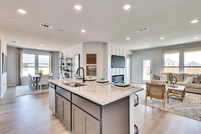 6500 Smarty Jones Ln, Buda, TX 78610 - kitchen with open floor plan, light wood-style flooring, gray cabinetry, light stone countertops, and recessed lighting