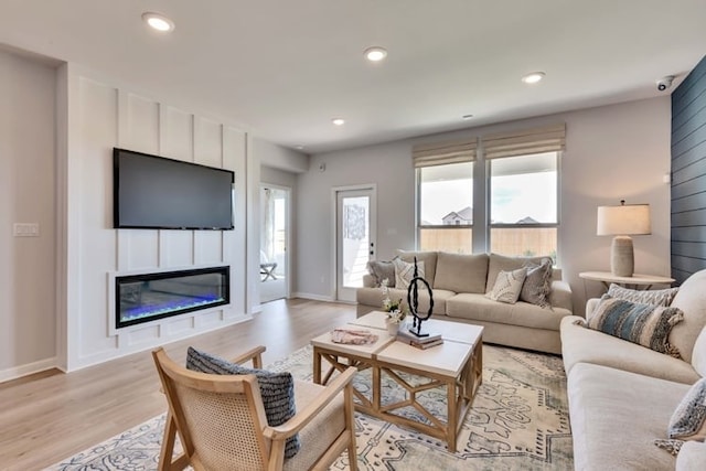 6500 Smarty Jones Ln, Buda, TX 78610 - living room featuring light wood-style floors, a glass covered fireplace, and recessed lighting