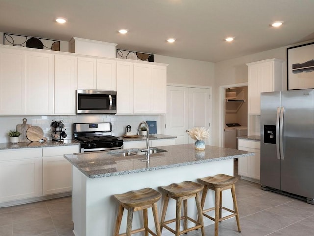 208 Morning Tide Dr, Georgetown, TX 78628 - kitchen featuring stainless steel appliances, washing machine and dryer, decorative backsplash, light tile patterned floors, and recessed lighting
