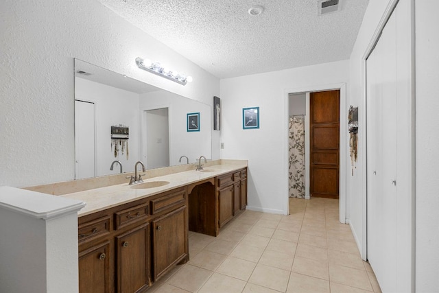 706 Cambridge Dr, Round Rock, TX 78664 - bathroom featuring double vanity, a textured ceiling, and tile patterned flooring