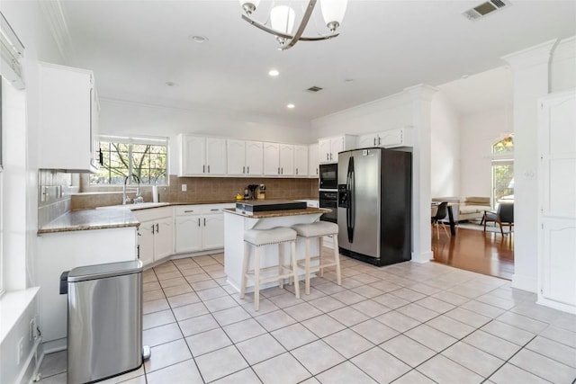 6100 Open Range Trl, Austin, TX 78749 - kitchen featuring black appliances, ornamental molding, backsplash, a center island, and a chandelier