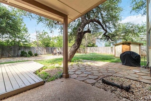 6100 Open Range Trl, Austin, TX 78749 - fenced backyard with a storage unit, a patio area, a grill, and a wooden deck