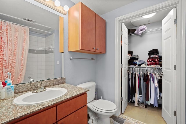 2502 Leon St Unit 102, Austin, TX 78705 - full bath featuring a walk in closet, vanity, a shower with shower curtain, and tile patterned flooring
